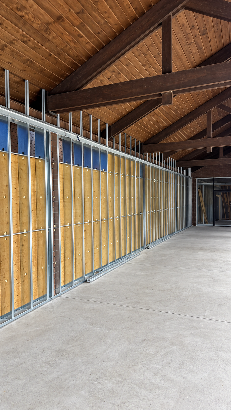 Exterior steel stud framing installed beneath an existing timber canopy